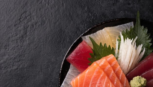 sashimi selection with salmon, tuna and yellowtail, beautifully arranged with daikon, shiso leaves and wasab