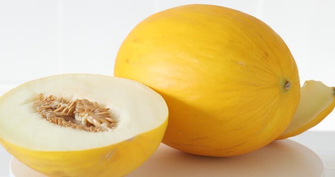 Whole and cut fresh sweet melons on table, closeup