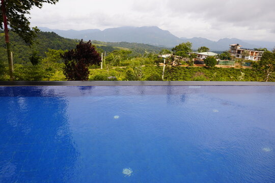 Blue Swimming Pool Overlooking Lush Green Mountains in Sri Lanka
