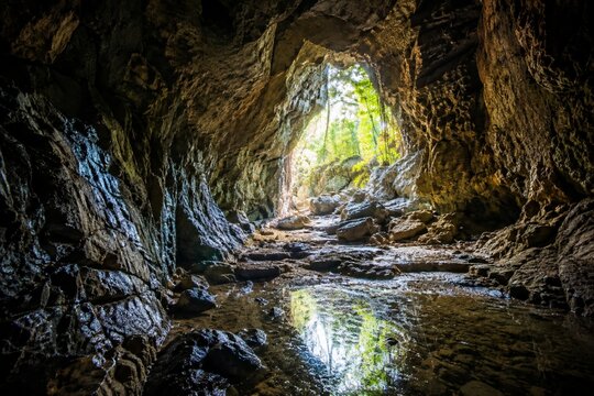 Natural rocky cave interior with sunlight at the entrance