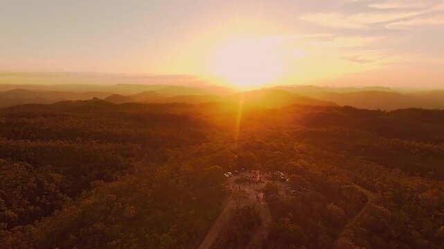 Golden sunrise illuminates the Cerrado, wooded hills and distant plateaus around Mirante de Sao Jorge in Alto Paraiso de Goias, Goias, Brazil, drone pullback.