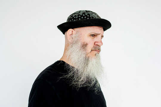 Man with a long white beard and hat, wearing a black shirt.