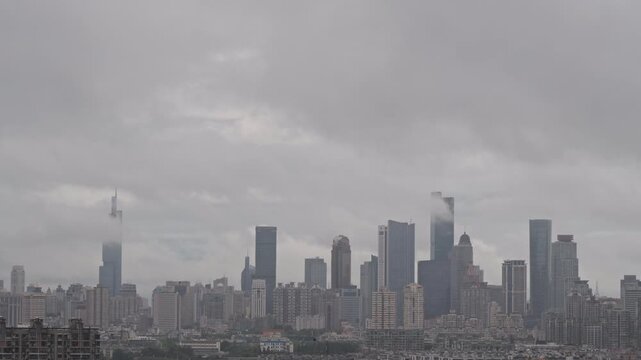 Modern city skyline disappearing into dramatic low clouds