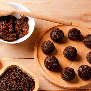 Classic Brazilian chocolate and sprinkle treat known as brigadeiro, presented in a rustic style on a wooden table.
