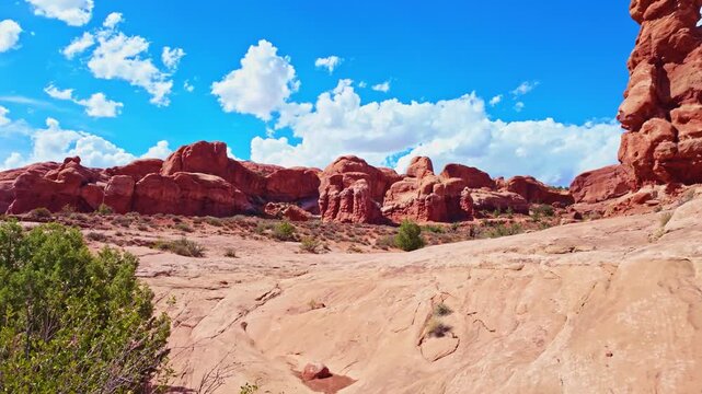 Towering eroded red rock monolith stands against blue skies in Arches National Park near Moab Utah