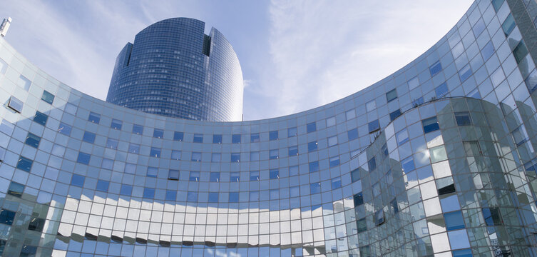 PARIS, FRANCE - SEPTEMBER 1, 2026 - Modern glass facades of office buildings reflecting the sky in La Defense, Paris
