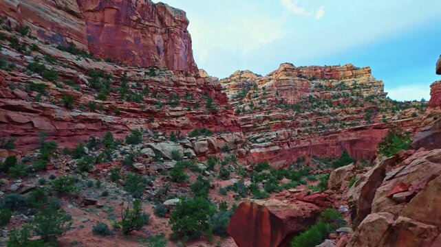 Vast red rock walls and sandstone cliffs tower over Grand Wash canyon along the Cassidy Arch trail in Capitol Reef National Park Utah