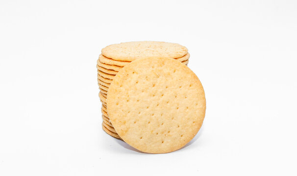 Stakced round crackers potato biscuits isolated on white background, Dry cracker cookies isolated, snack and fastfood concept. Crispy savory snack with golden texture.