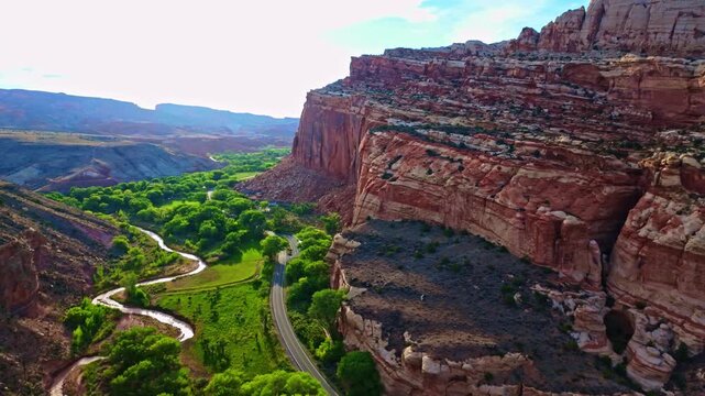 Warm sunset light bathes the lush Fruita Valley and surrounding red rock cliffs from the Cohab Canyon overlook in Capitol Reef Utah