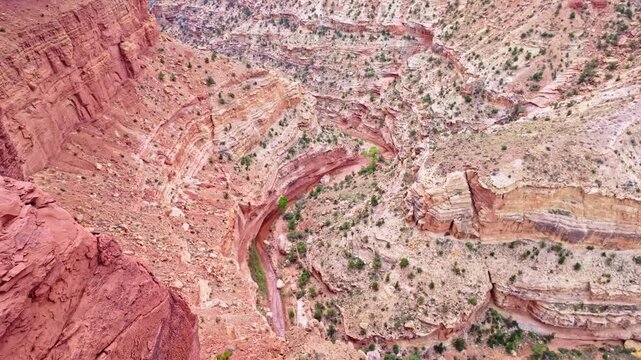 Deep carved canyon chasm drops dramatically below Goosenecks Overlook in Capitol Reef National Park Utah