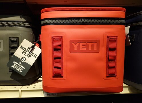 Newark, Delaware, U.S.A - Aug 10, 2026 - Red YETI Hopper Flip 12 soft cooler displayed on shelf with front logo, tag, and accessory webbing points.
