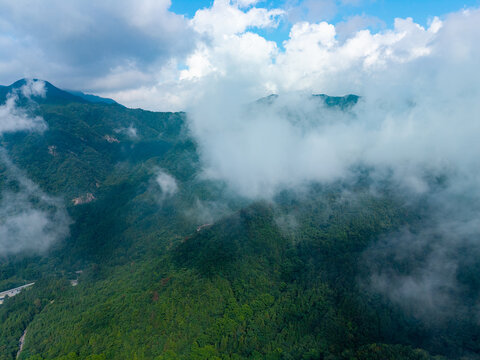 Aerial view of the lush green mountains in the Dabie Shan range located in the Hubei province of China with thick clouds drifting over the forested peaks