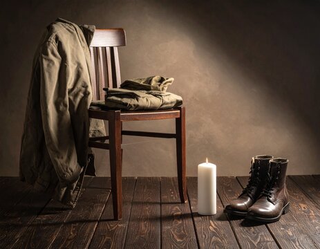 Rustic Interior Still Life with Military Coat Hanger, Wooden Chair, Leather Boots, and Candlelight