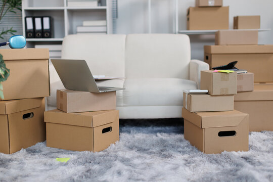 Cardboard boxes filling a living room, symbolizing moving, relocation, new beginnings, shipping, and home office logistics for a small business setup