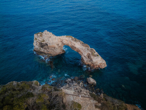 Drone shot of Natural arch in the mediterranean sea at sunrise, en Pontas,Santanyi, Mallorca, Spain. travel banner with copy space
