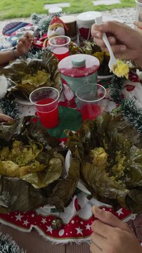 People eating christmas tamales together outdoors