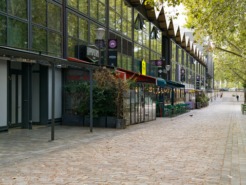 PARIS, FRANCE - SEPTEMBER 1, 2026 - Bercy Village features modern buildings lining a historic cobblestone street with outdoor cafe seating