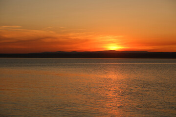 Obraz premium Soft pink and orange sunset over quiet waters and sandy shore in East Kazakhstan. Minimalistic