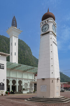 White clock tower and minaret of a traditional mosque against blue sky with islamic architecture religious building cultural site architecture building structure landmark religion exterior
