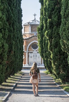 Young woman on the main path of the cemetery island San Michele, Venice, Italy