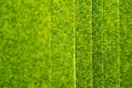 textura de capas de pasto verde corto sint&eacute;tico con primer plano desenfocado