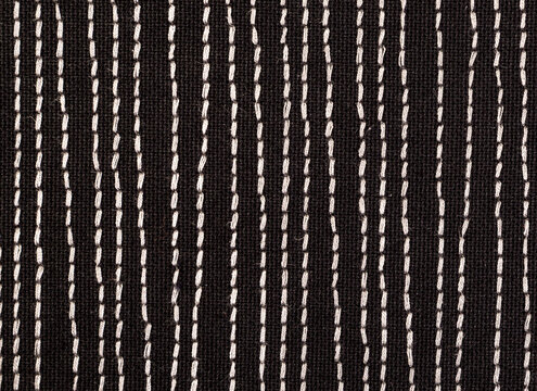 Black fabrick with white stitches background texture