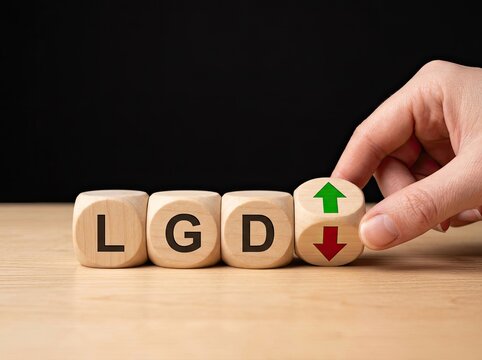 Hand turning wooden cubes with LGD acronym and directional arrows suitable for banking presentation symbolizing financial risk management