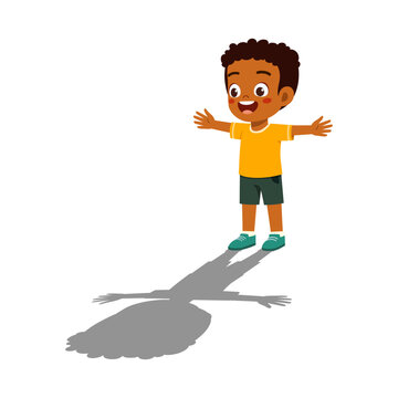 Happy African American boy standing with open arms wide and smiling broadly while casting a shadow feeling joyful