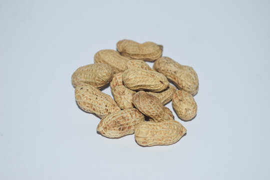 Pile of whole raw peanuts in shell isolated on white background