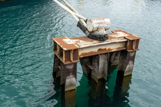 Metal mooring block in the water with ropes securing boats and vessels, showing a sturdy marine anchoring system used for docking, harbor infrastructure, boating and waterfront transportation