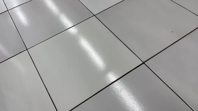 Bright light reflections on shiny white ceramic floor tiles texture