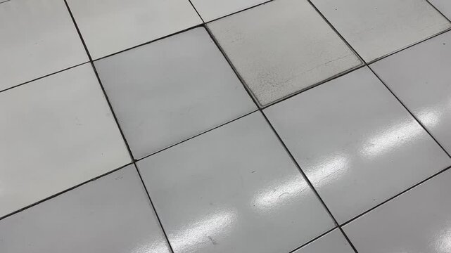 Diagonal view of white ceramic tile flooring texture with light reflection