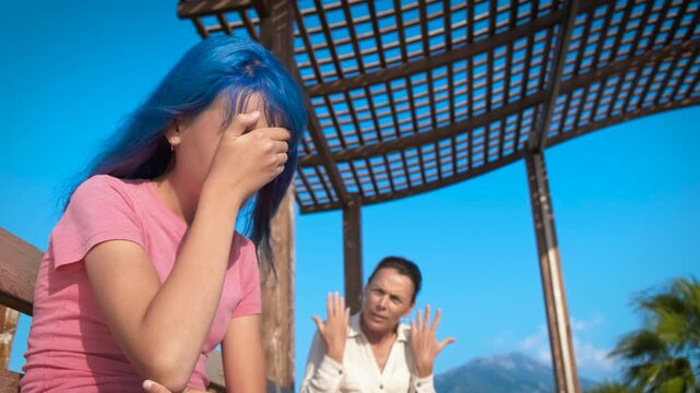 Mother quarrel in vacation. An angry mother quarrel with her teenage daughter on the tropical shore during weekend time