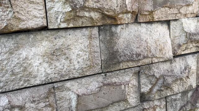 Natural stone wall texture with dramatic shadow and sunlight contrast