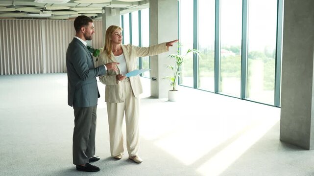 Real estate agent showing new empty office space to client