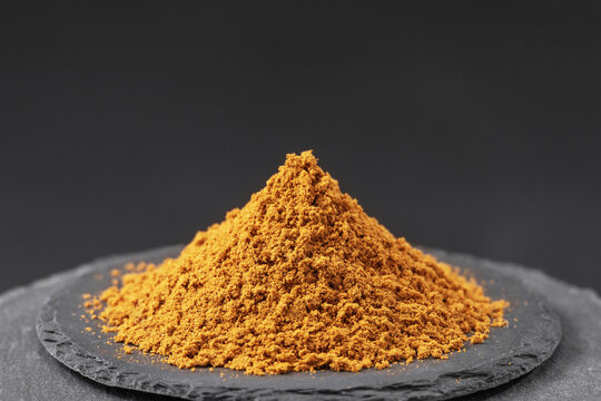 dried cumin seed powder on a black slate stone tray