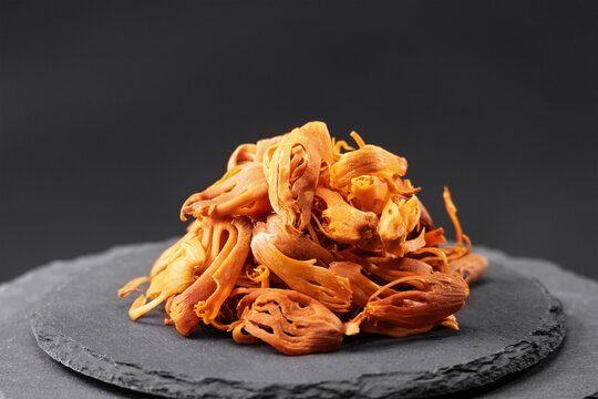 mace nutmeg shell, seed coat of the myristica fragrans tree on a black slate stone tray