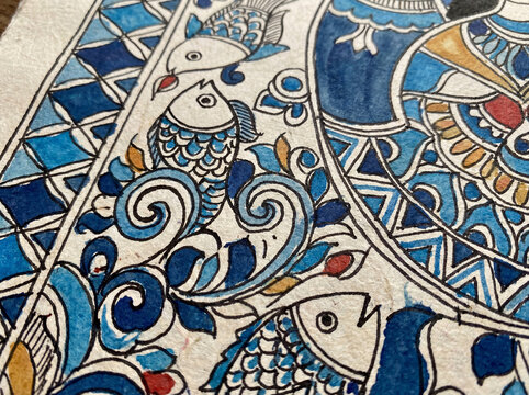 Close-up of traditional Madhubani painting from Mithila, Bihar, featuring hand-drawn fish, floral and geometric motifs in vivid colors on textured handmade paper