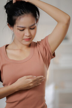 Breast cancer awareness concept. Woman performs breast self examination at home, checking her breast. cancer, examination, awareness, prevention.