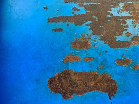 Oxidation Abstract: Close-up of rust patches and peeling blue paint on a metal surface, creating an abstract texture reminiscent of a map or a weathered landscape.