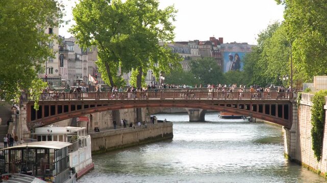 Tourists Crossing Pont au Double Bridge Near Notre Dame in Paris
