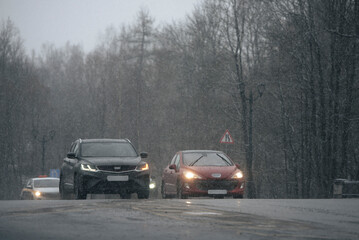 Fototapeta premium Heavy Snowfall Traffic on Wet Winter RoadRussia, Leningrad Region, 2025.