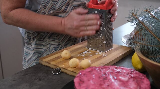 Preparing a traditional family salad. Grating eggs.