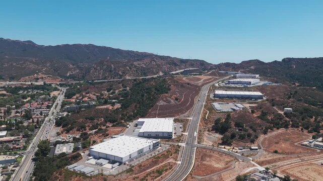 High reverse pullback aerial shot of an industrial park in Newhall, California. 4K