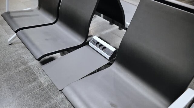 Power outlets between airport seats support smartphone charging in Riga