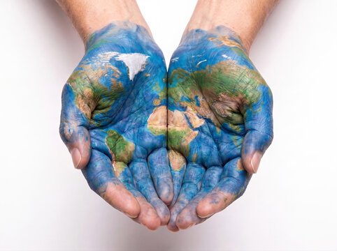 Painted earth map on cupped hands and palms with skin texture and fingers holding the world