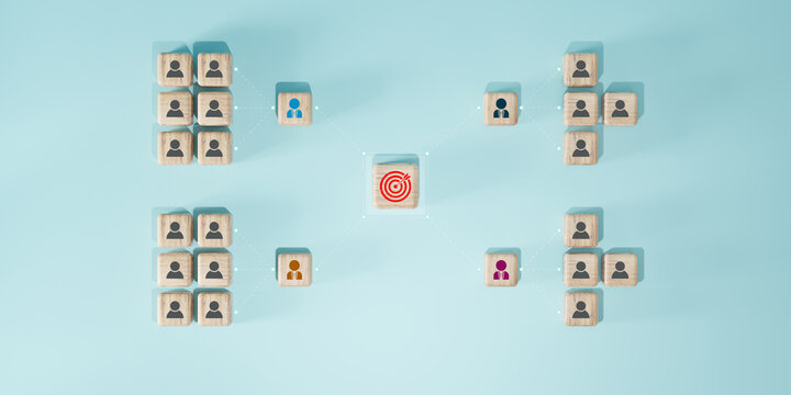 Wooden blocks with human icons arranged in team structure connecting to target icon center, business organization goal alignment, teamwork.