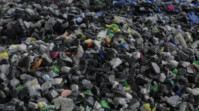 Pile of shredded mixed plastic flakes after grinding inside a recycling factory