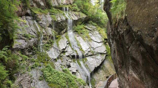 Cascading waterfall and wooden walkway in the lush Wimbachklamm gorge, Bavaria