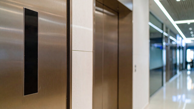 Empty modern office corridor with closed elevator doors